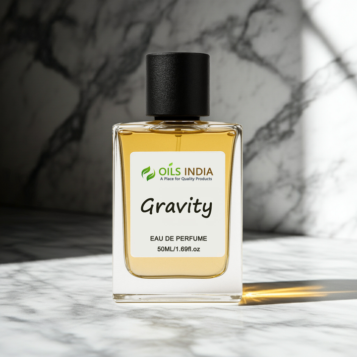 Perfume bottle labeled 'Gravity' by Oils India on a marble surface with a blurred background
