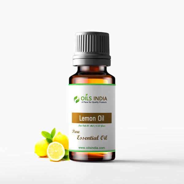A bottle of Lemon Oil with a black cap, standing next to a couple of lemons and some leaves on a white background.