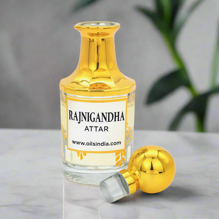 Gold and clear bottle of Rajnigandha Attar with a white label on a white background by oils india